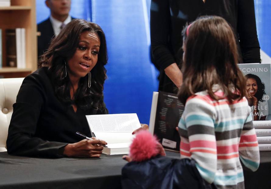 Former first lady Michelle Obama signs copies of her memoir "Becoming" at the Seminary Co-op Bookstore in Chicago