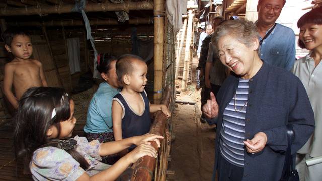 FILE PHOTO: United Nations High Commissioner for Refugees Sadako Ogata talks to a young refugee family from Myanmar at their camp in Thailand