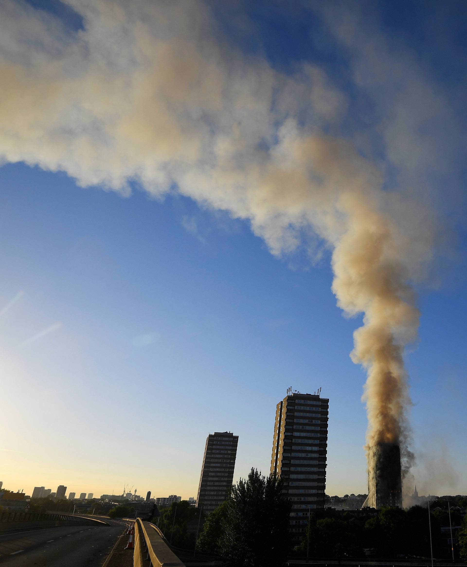 The A40 road is seen closed as flames and smoke billow as firefighters deal with a serious fire in a tower block at Latimer Road in West London