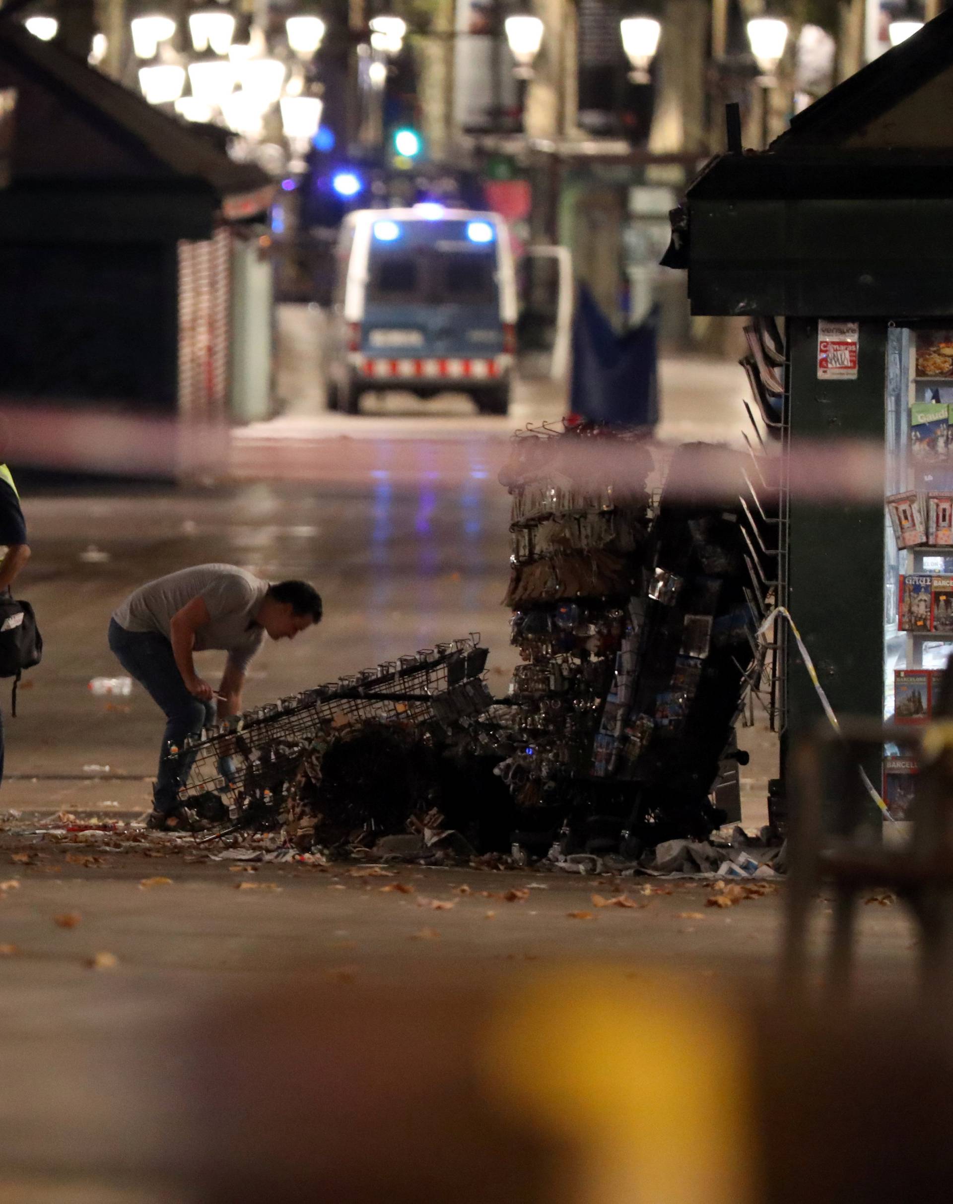 Forensic police officers search for clues near the area where a van crashed into pedestrians at Las Ramblas in Barcelona