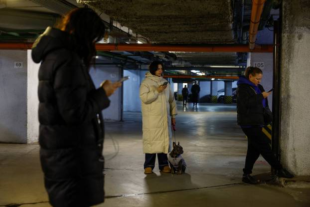 People take shelter inside an underground parking lot during a Russian missile and drone attack in Kyiv