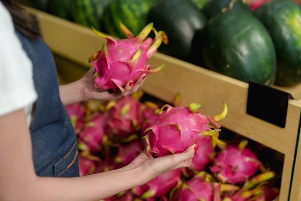 Close-up,Of,Hands,Holding,Two,Pink,Dragon,Fruits,In,Tropical