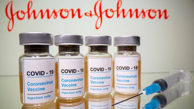 FILE PHOTO: Vials and medical syringe are seen in front of J&J logo in this illustration