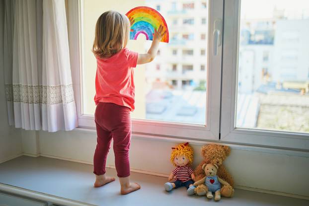 Adorable,Toddler,Girl,Attaching,Rainbow,Drawing,To,Window,Glass,As