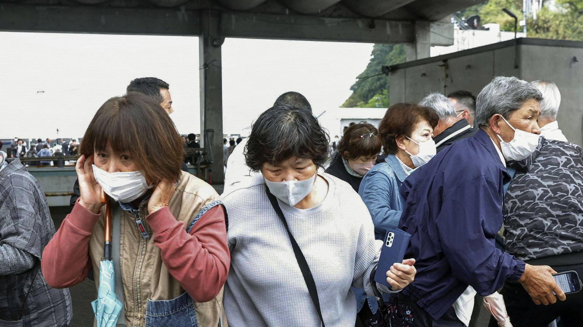 Residents try to flee after a man threw a pipe-like object near Japanese Prime Minister Fumio Kishida during his outdoor speech in Wakayama