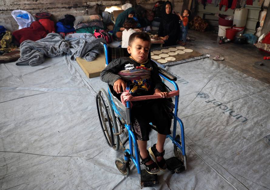 Joud, the nephew of displaced Palestinian Majed al-Bareem, sits in a wheelchair inside an UNRWA school where they shelter, in Khan Younis, in the southern Gaza Strip