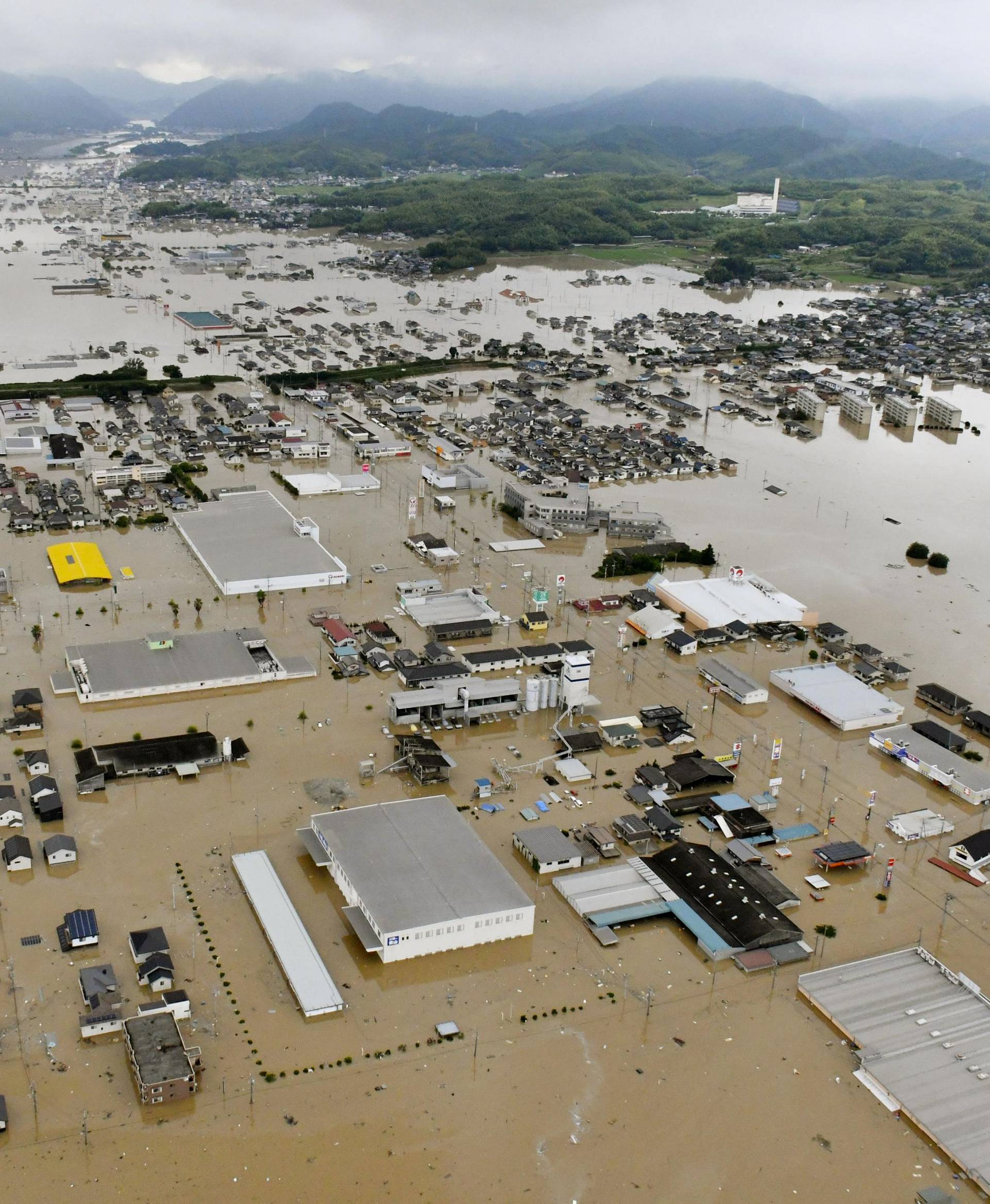 An aerial view shows submerged houses and facilities at a flooded area in Kurashiki