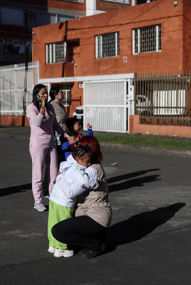 People gather outside a building following an earthquake in Bogota