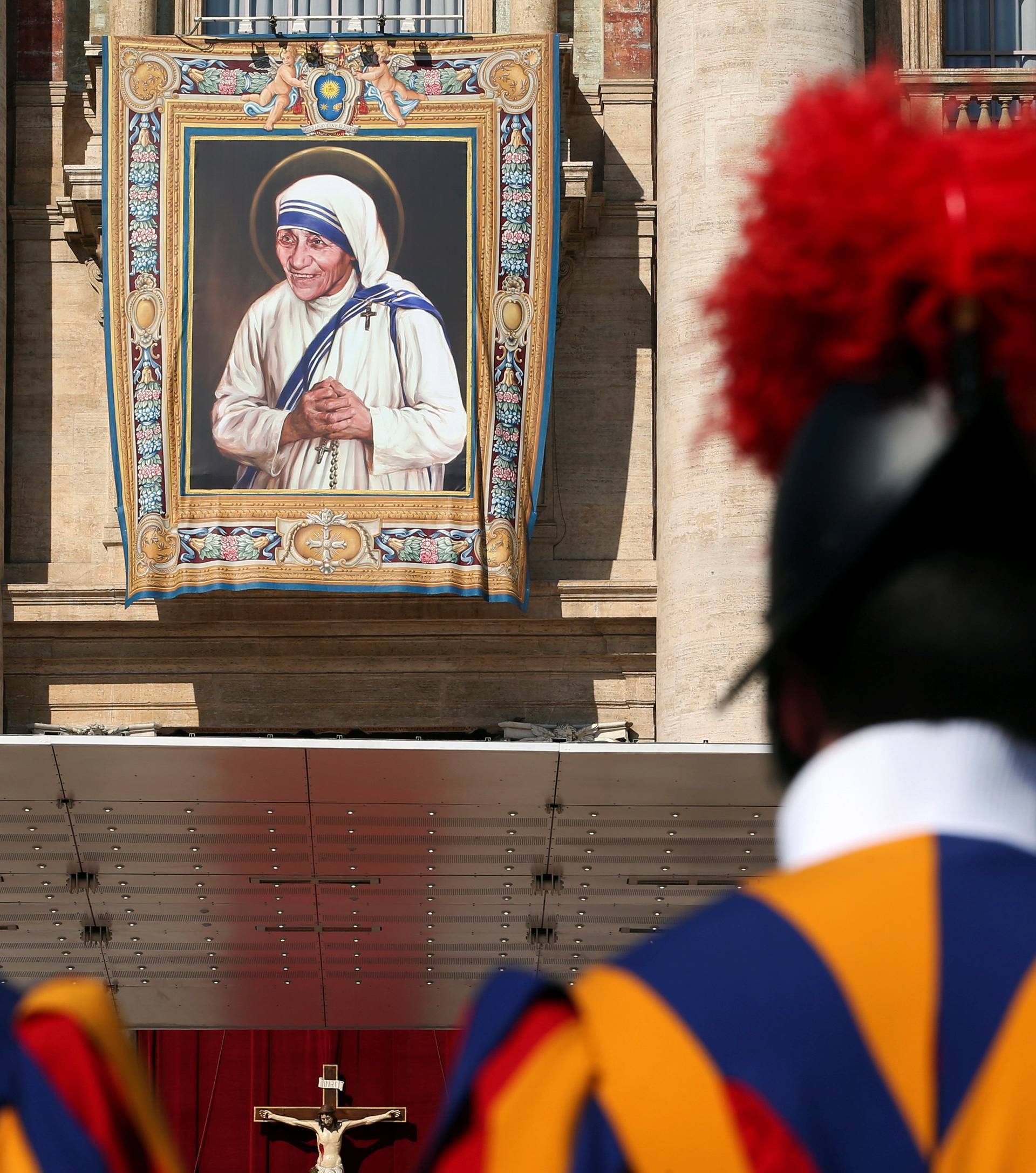 Swiss Guards stand in front of a tapestry depicting Mother Teresa of Calcutta before a mass, celebrated by Pope Francis, for her canonisation in Saint Peter's Square at the Vatican