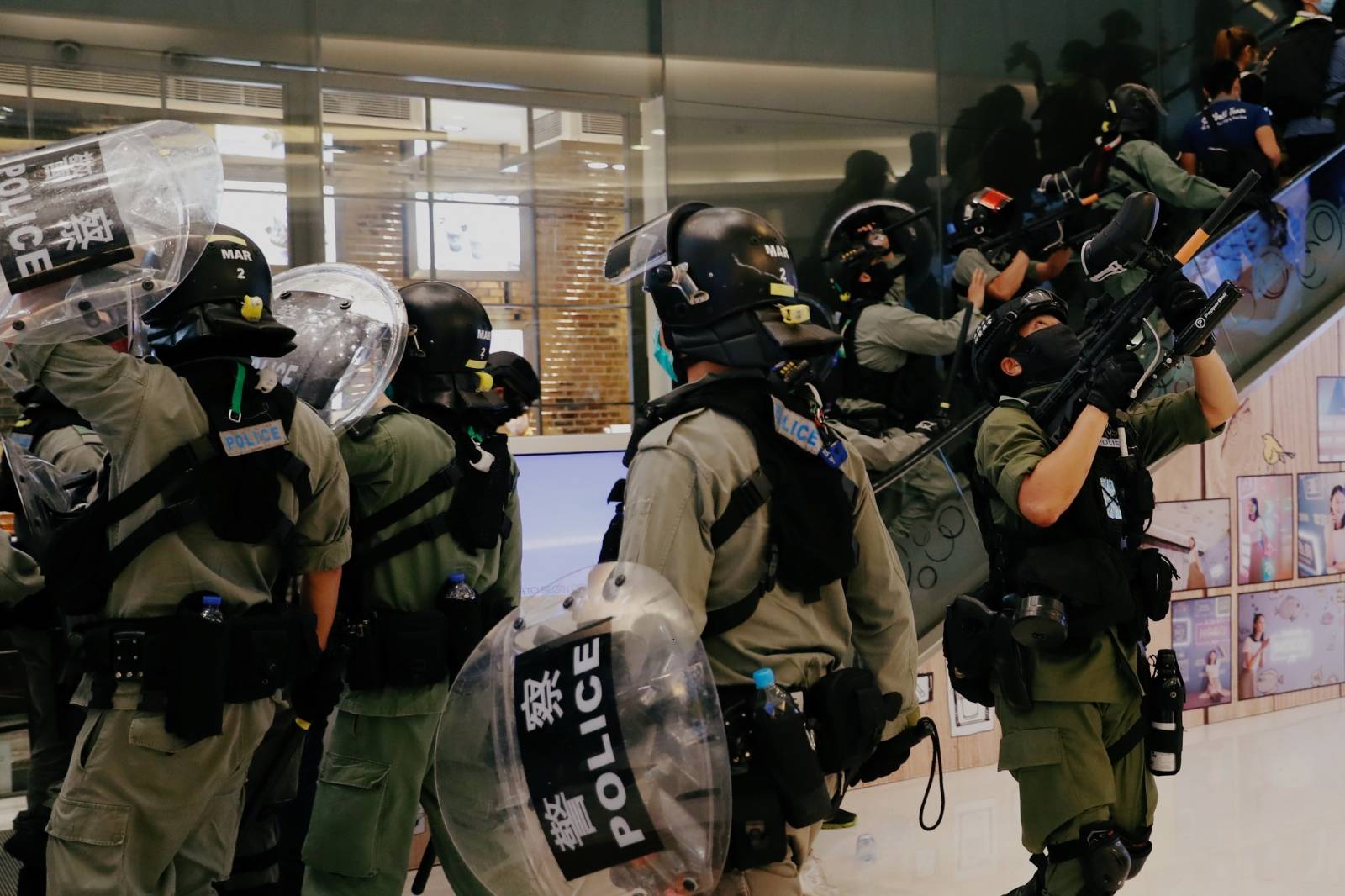 Riot police raise their pepper spray projectile inside a shopping mall as they disperse anti-government protesters during a rally, in Hong Kong