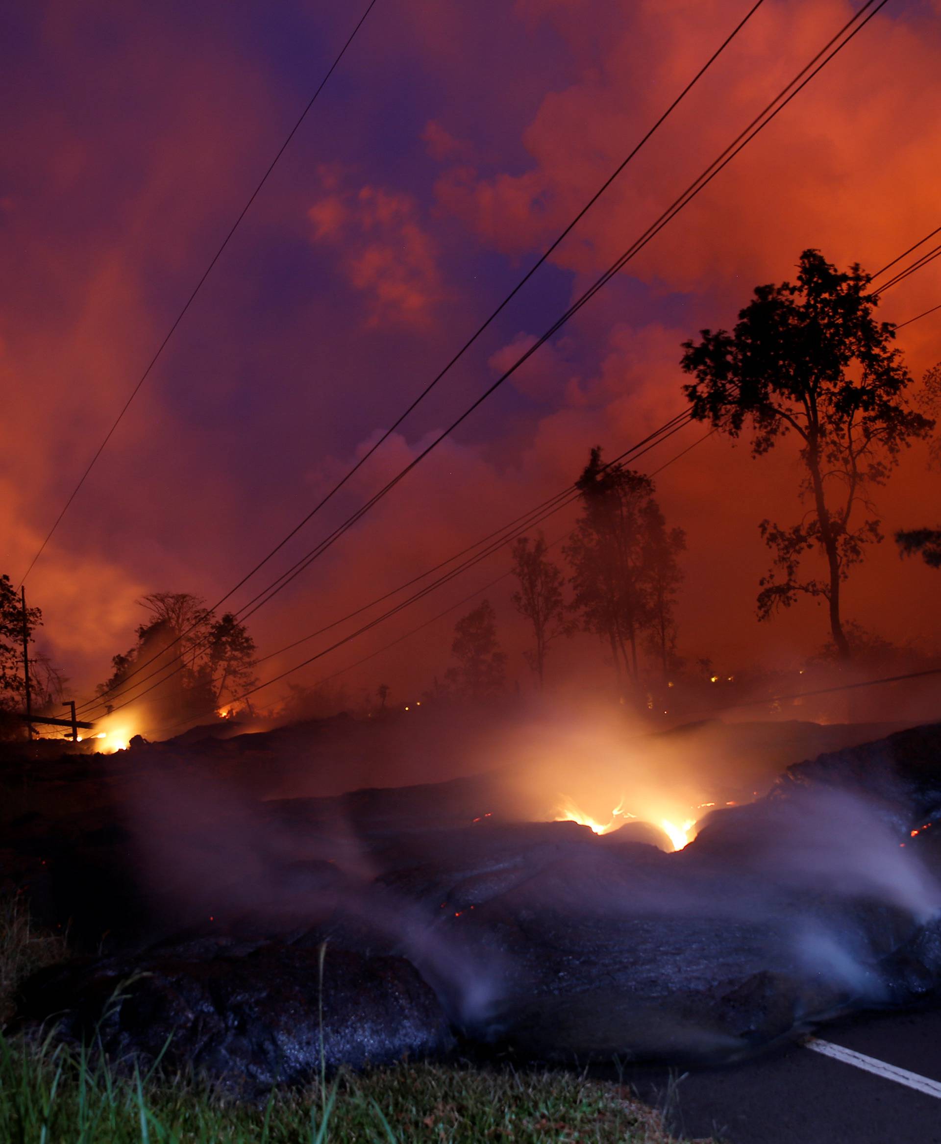 Volcanic gases rise from the Kilauea lava flow that crossed Pohoiki Road near Highway 132, near Pahoa, Hawaii