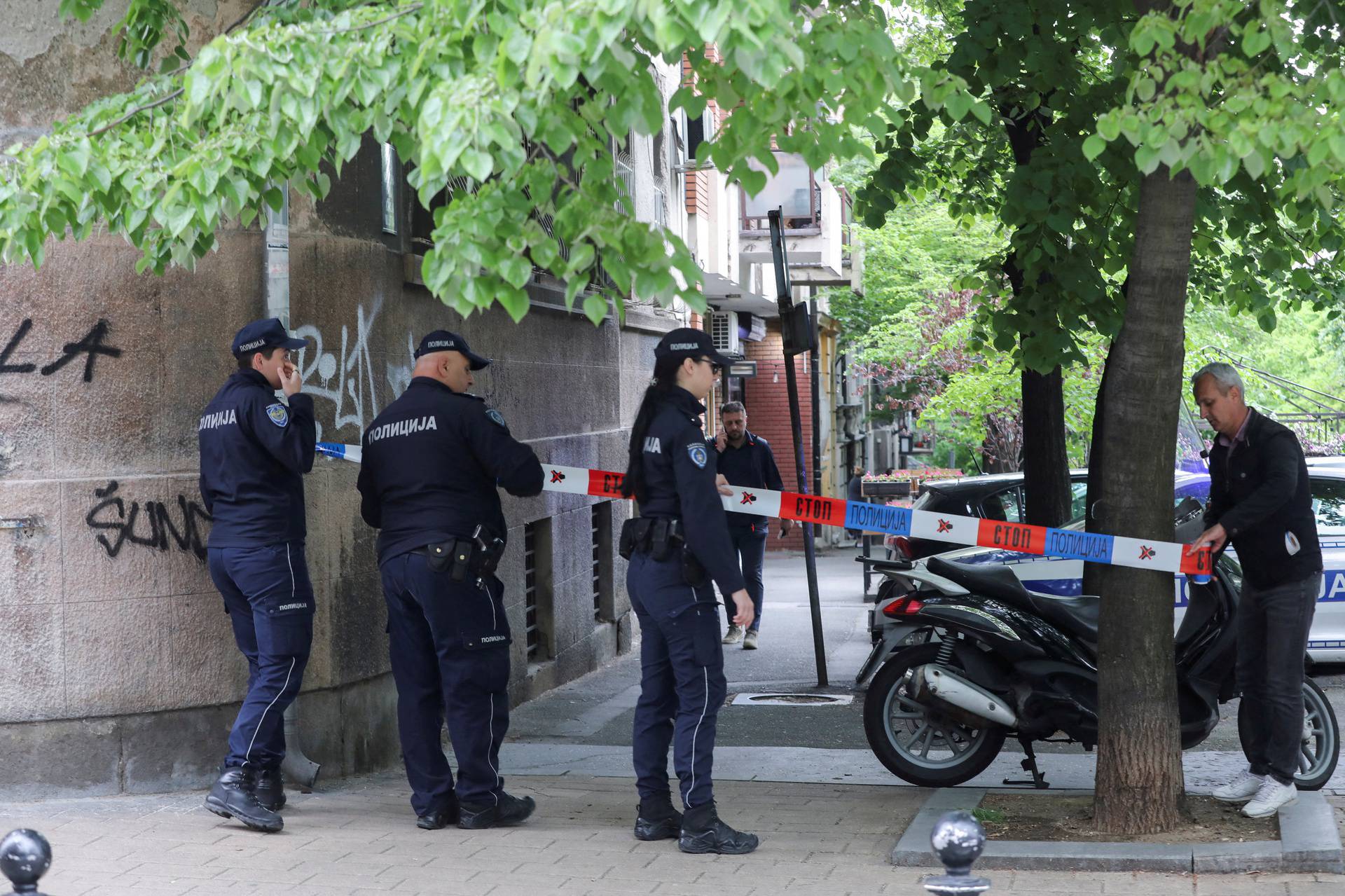 Police officers secure the area after a 14-year-old boy opened fire on other students and security guards at a school in downtown Belgrade