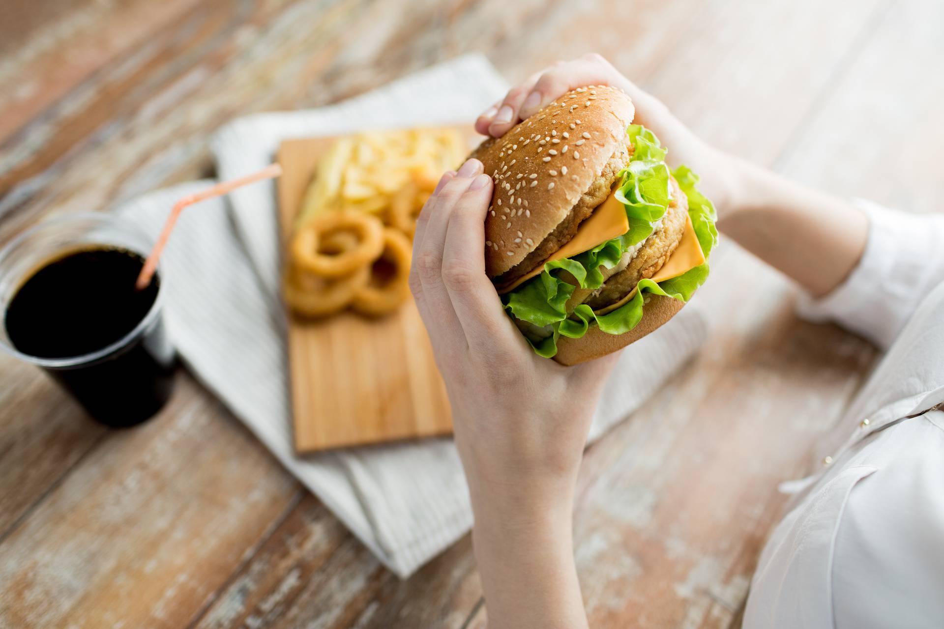 close up of woman hands holding hamburger