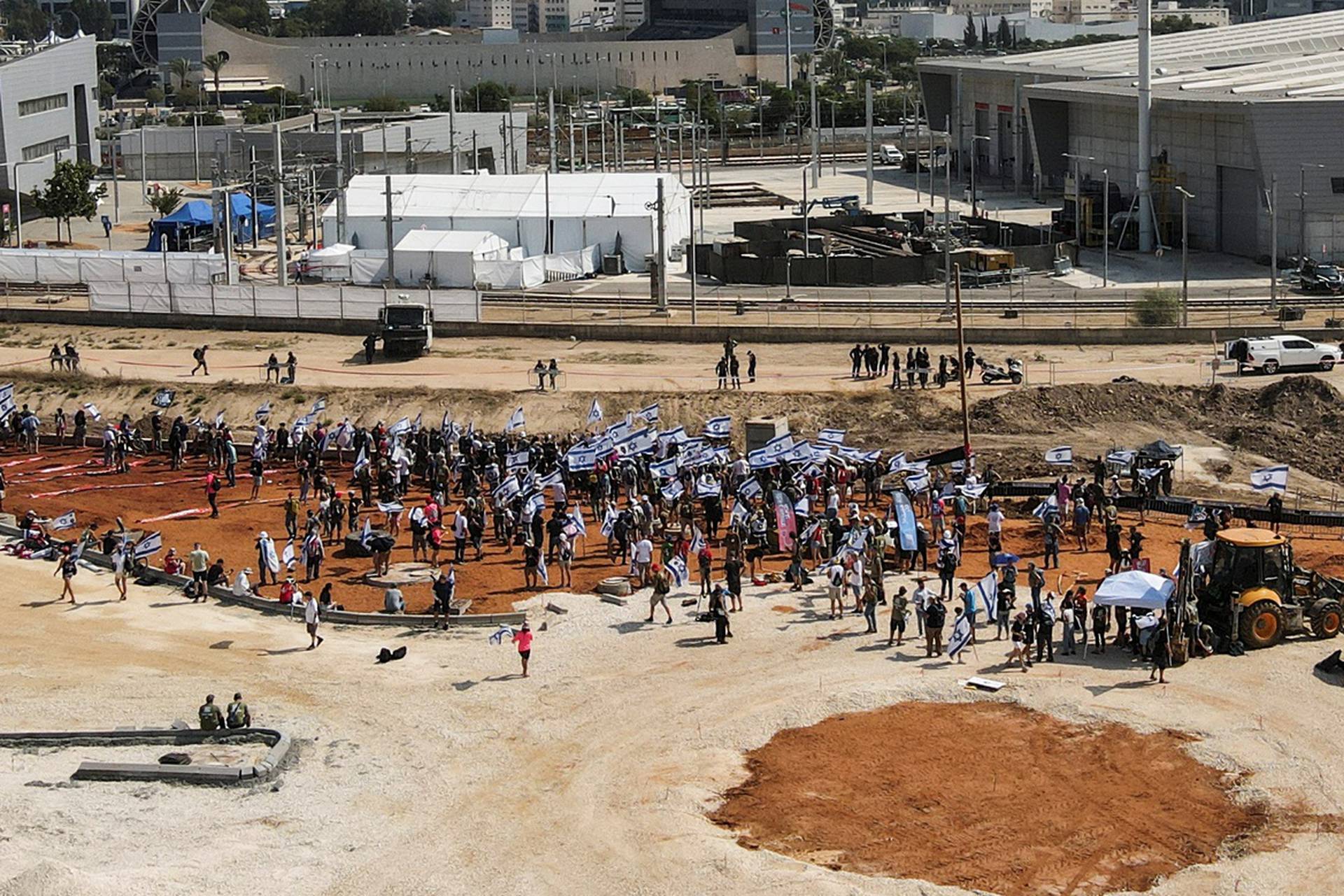 An aerial view shows people taking part in a demonstration against Israeli Prime Minister Benjamin Netanyahu's judicial overhaul near an inauguration event for Israel's new light rail line for the Tel Aviv metropolitan area, outside Petah Tikva