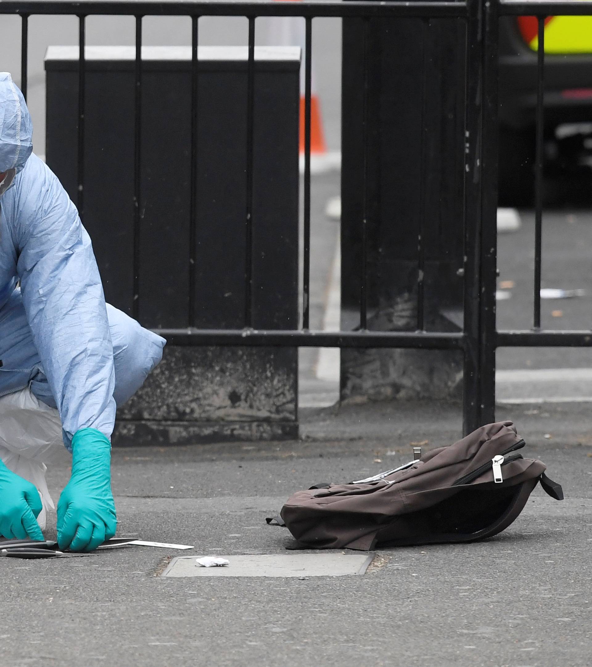 A forensic investigator recovers knives after man was arrested on Whitehall in Westminster, central London