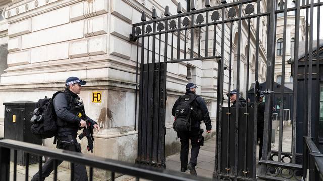 Police officers walk towards Downing Street in London