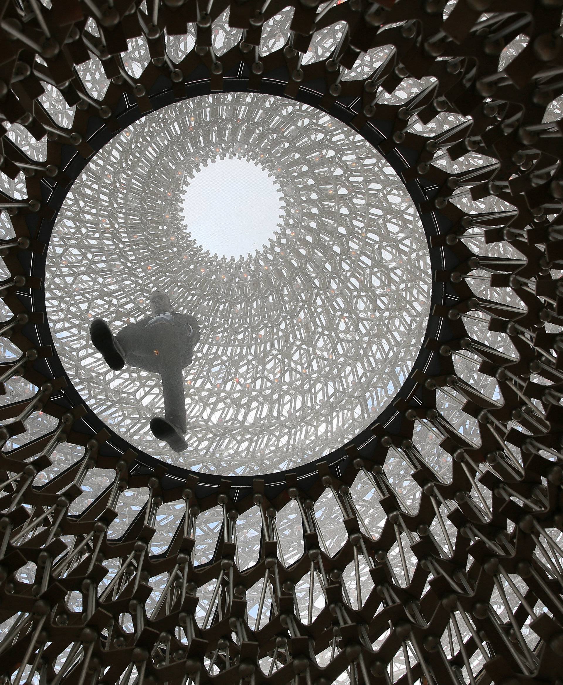 A visitor interacts with Wolfgang Buttress' sculpture The Hive at Kew Gardens in London