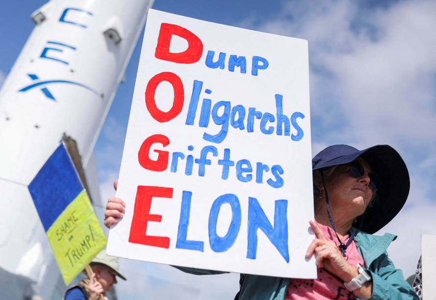 FILE PHOTO: Activists protest against cuts to government agencies by tech billionaire Elon Musk and his young aides at the DOGE, in Hawthorne, CA