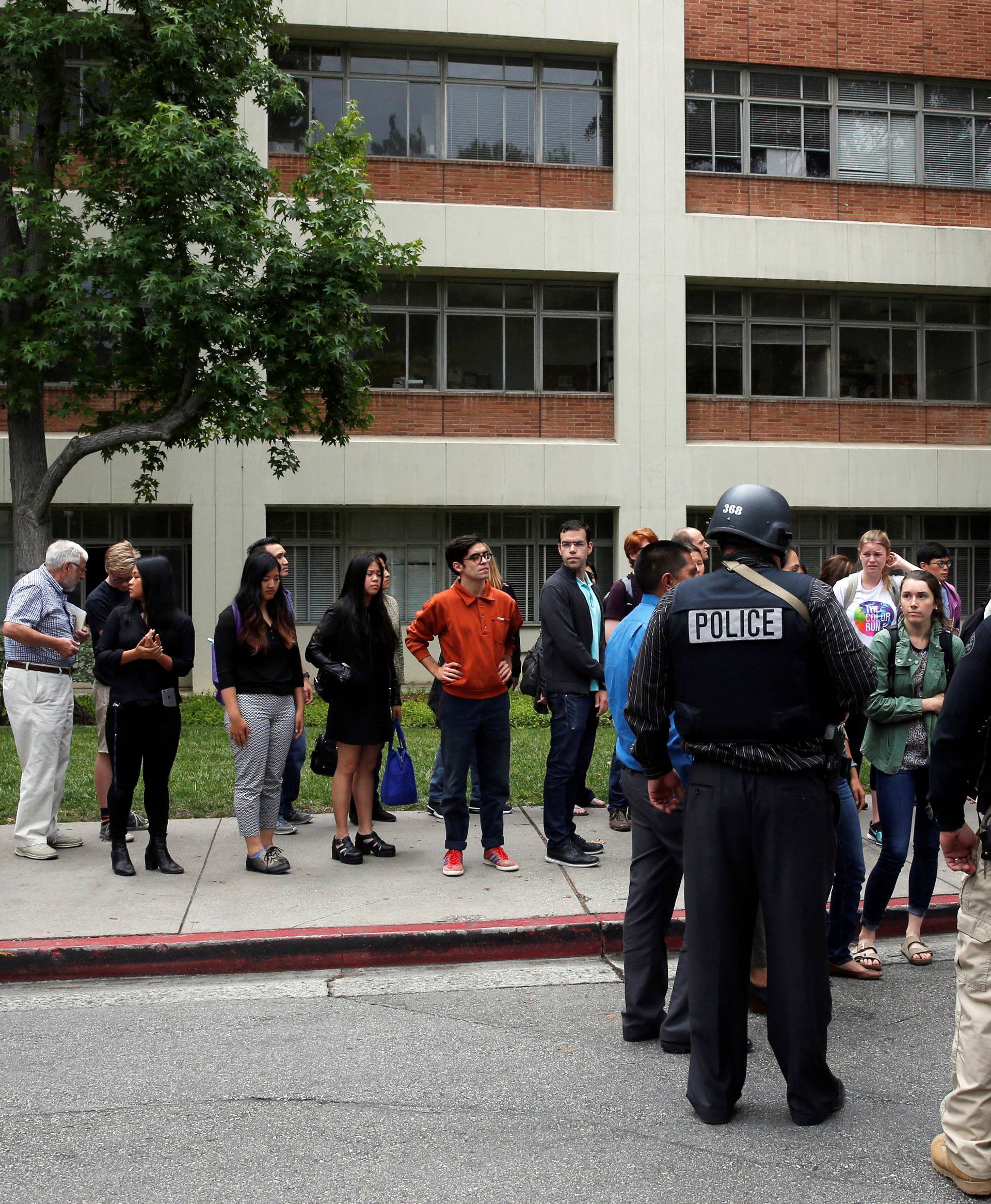 Police officers interview witnesses after conducting a search on people at the University of California, Los Angeles (UCLA) campus after it was placed on lockdown following reports of a shooter in Los Angeles