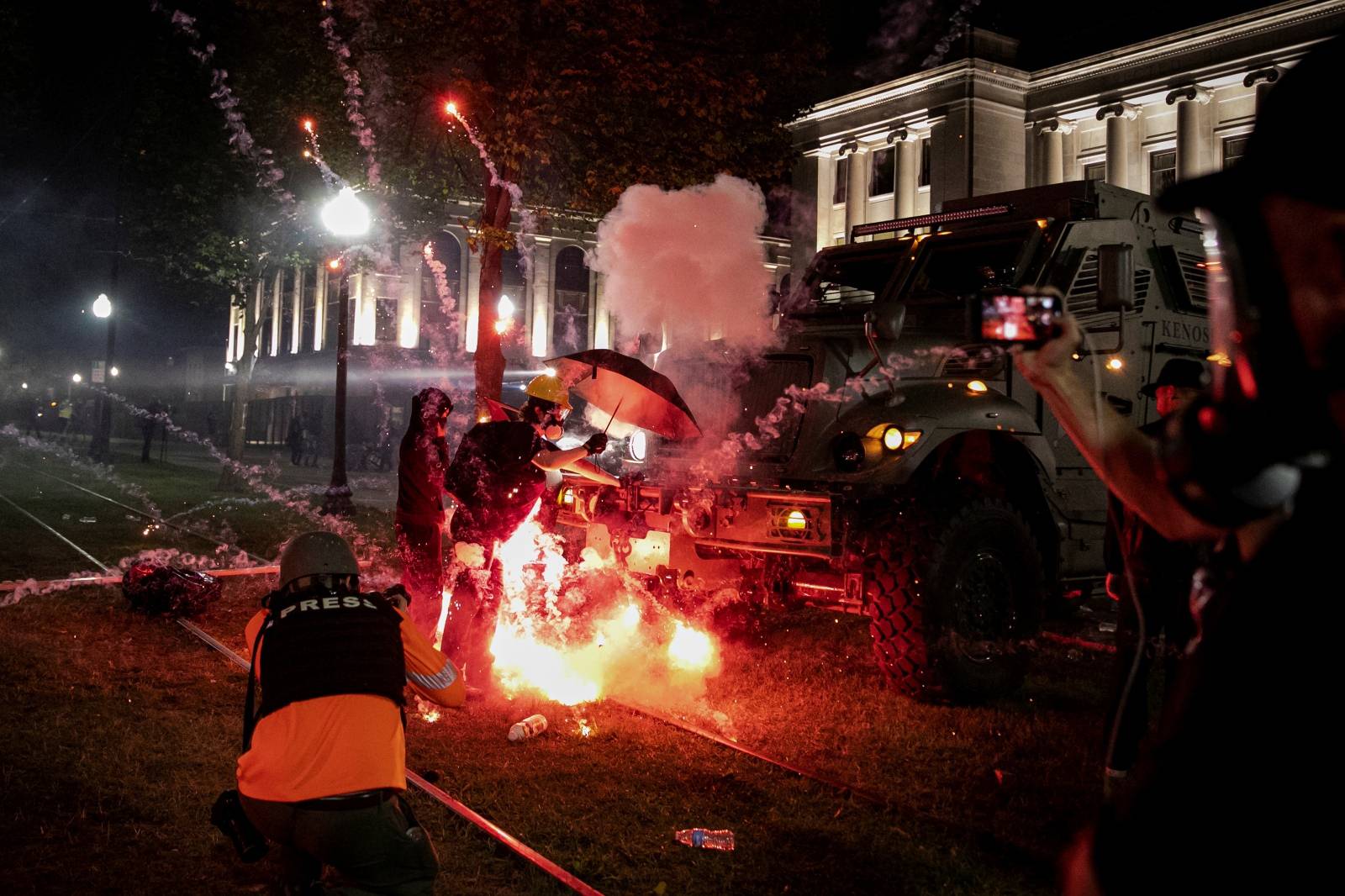 An incendiary device goes off in front of a Kenosha Country Sheriff Vehicle as demonstrators take part in a protest following the police shooting of Jacob Blake, a Black man, in Kenosha