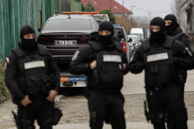 Romanian officials transport the cars seized from the Tate compund to a storage location
