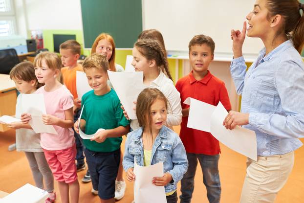 Female teacher rehearsing choir with students