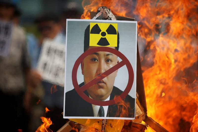 A cut-out of North Korean leader Kim Jong Un is set on fire during an anti-North Korea rally in central Seoul