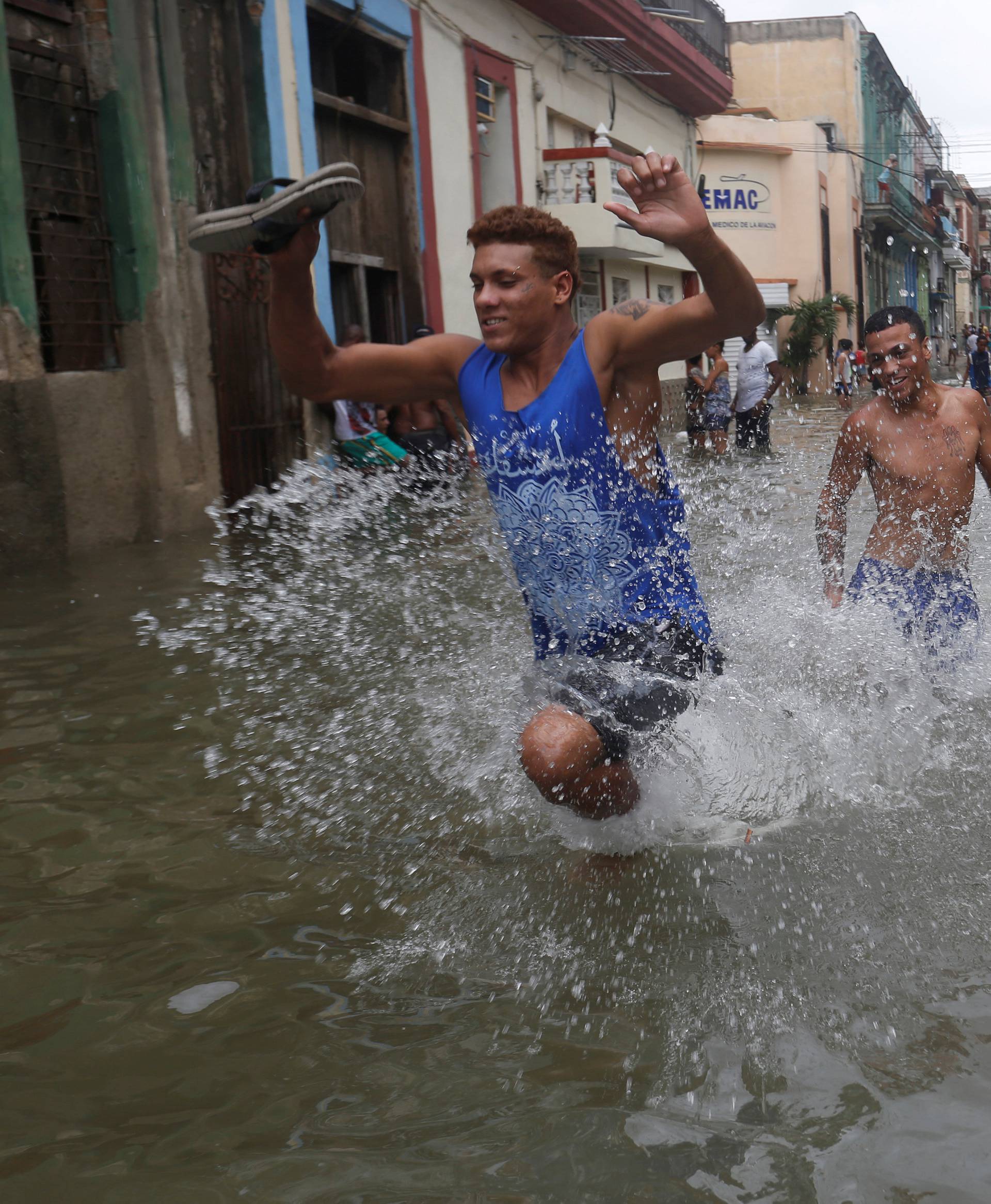 Men run through a flooded street, after the passing of Hurricane Irma, in Havana