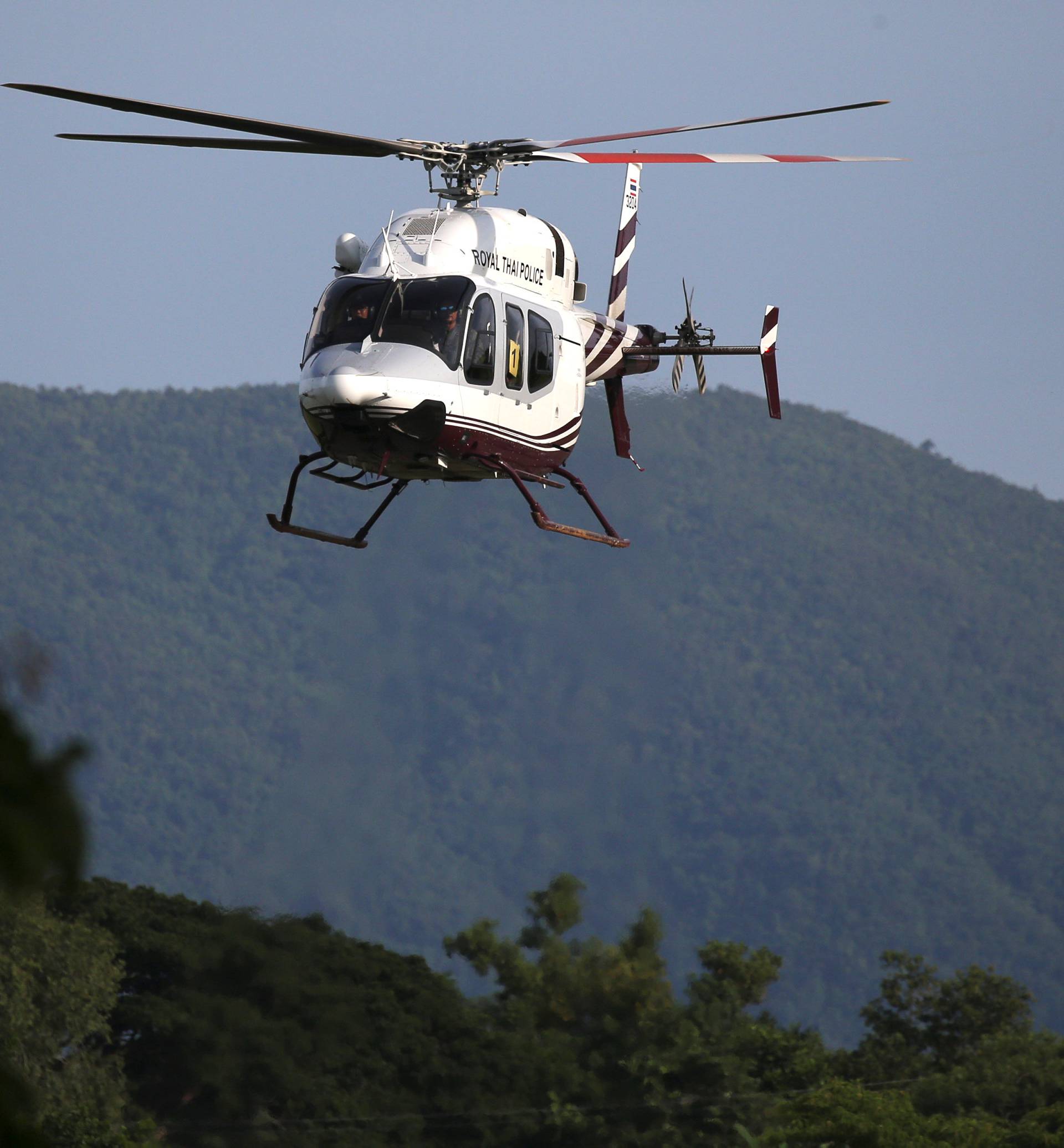 A military helicopter carrying rescued schoolboys approaches to land at a military airport in Chiang Rai