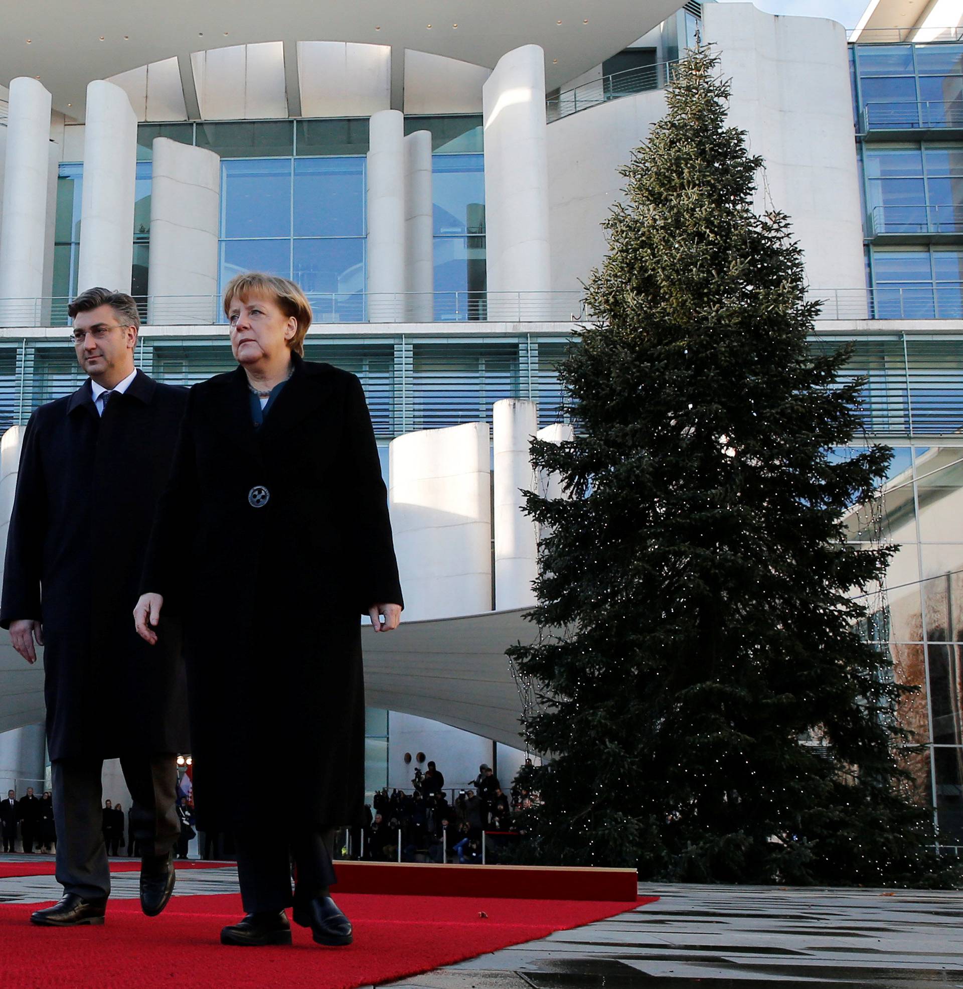 Croatia's Prime Minister Plenkovic and German Chancellor Merkel review the honor guard during a welcoming ceremony in Berlin