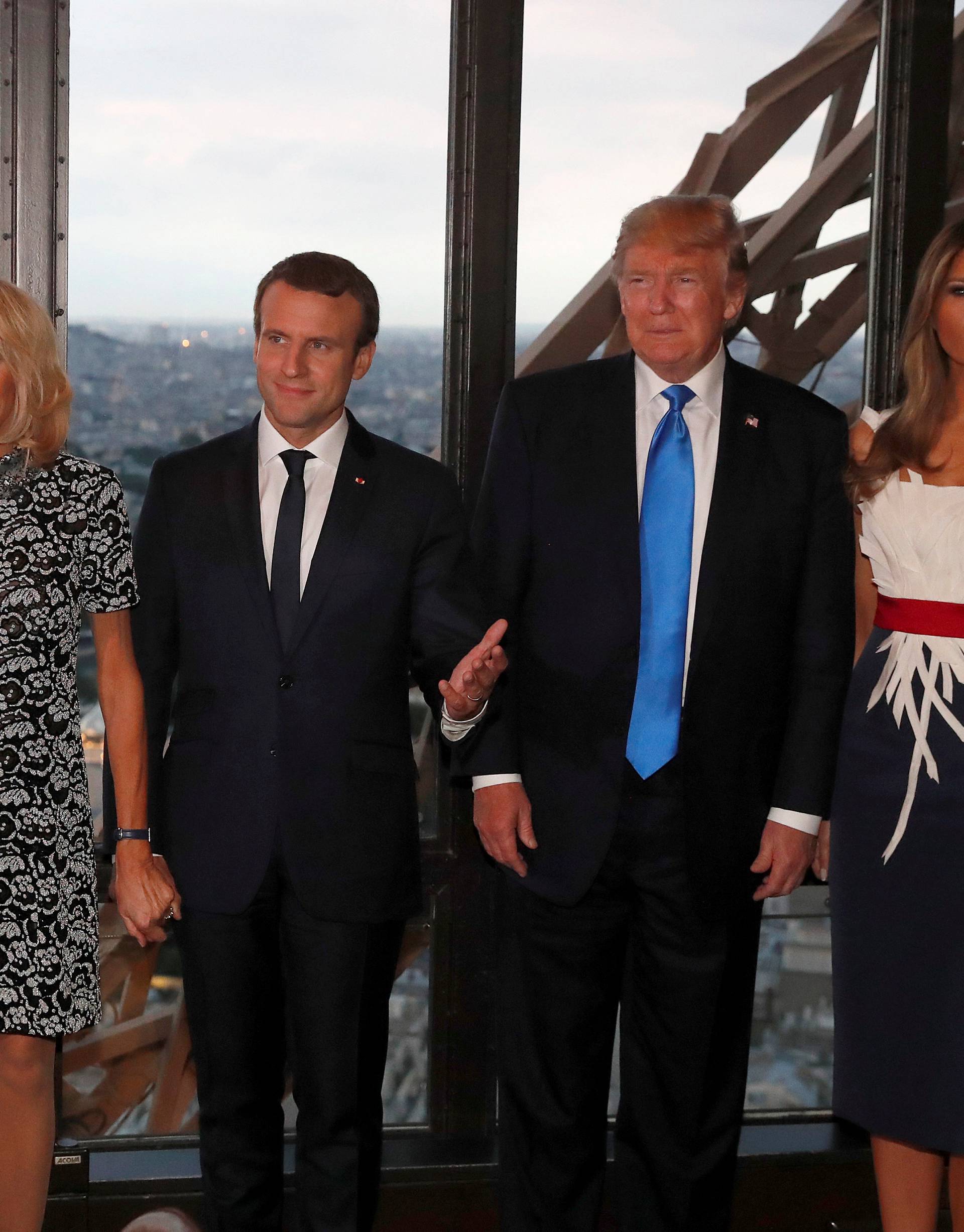From L-R, Brigitte Macron, wife of French President Emmanuel Macron, U.S. President Donald Trump and  First lady Melania Trump pose at the Jules Verne restaurant for a private dinner at the Eiffel Tower in Paris