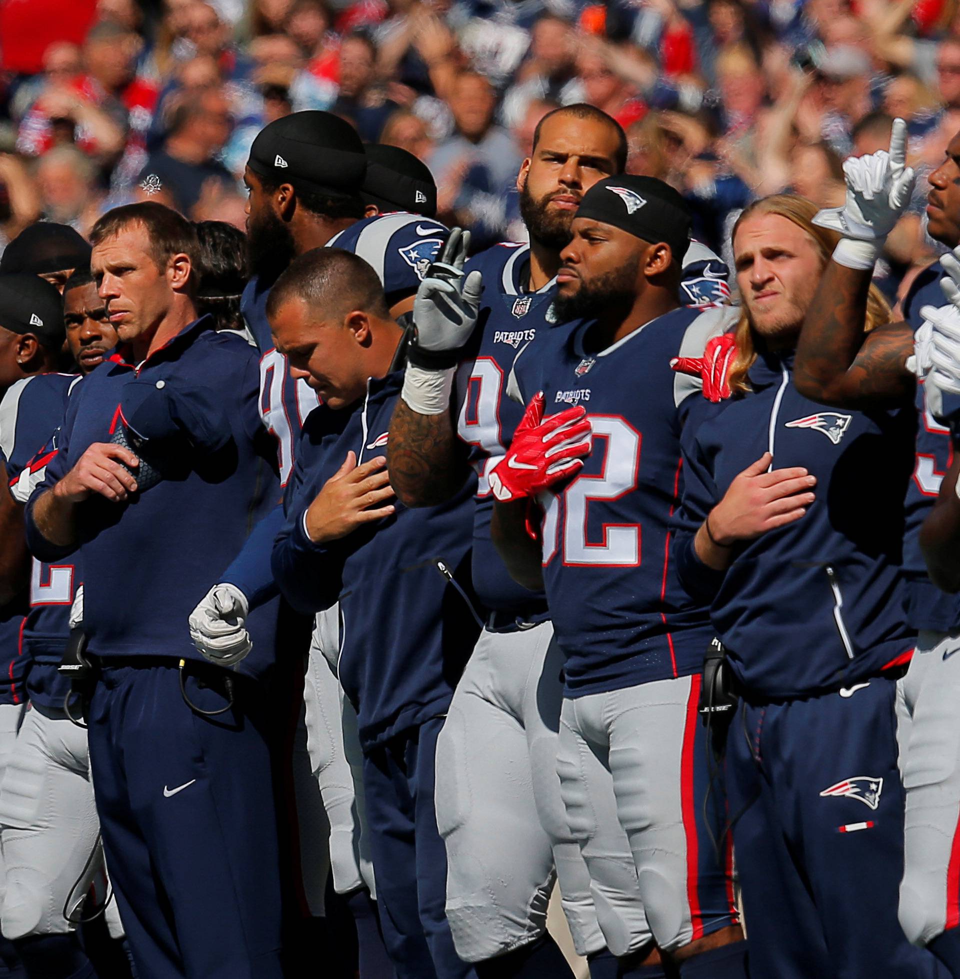 The New England Patriots players stand together for the U.S. National Anthem before their NFL football game against the Carolina Panthers in Foxborough