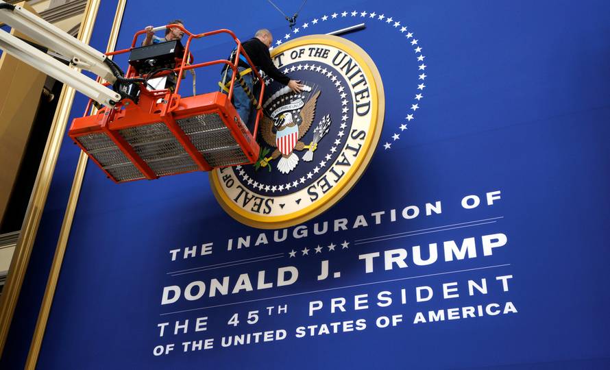 Workers install the presidential seal at the site of the Commander in Chief inaugural ball for President-elect Donald Trump in Washington, DC