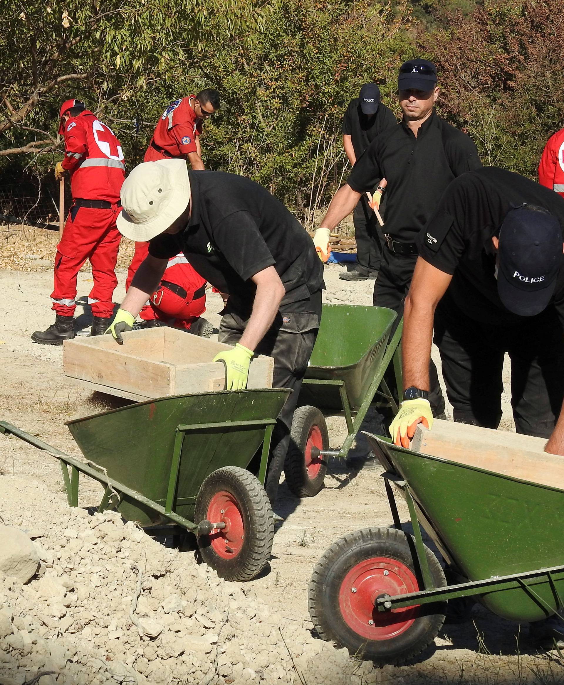 South Yorkshire police officers and members of the Greek rescue service investigate the ground while excavating a site during an investigation for Ben Needham on the island of Kos