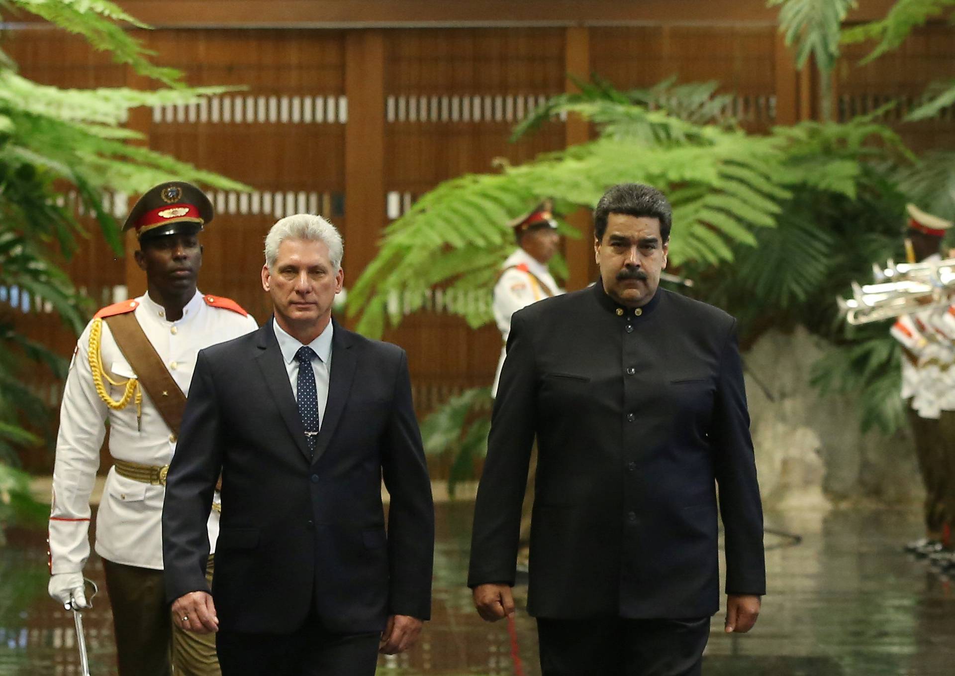 Cuban President Miguel Diaz-Canel and Venezuela's President Nicolas Maduro review an honour guard during a ceremony at the Revolution Palace in Havana