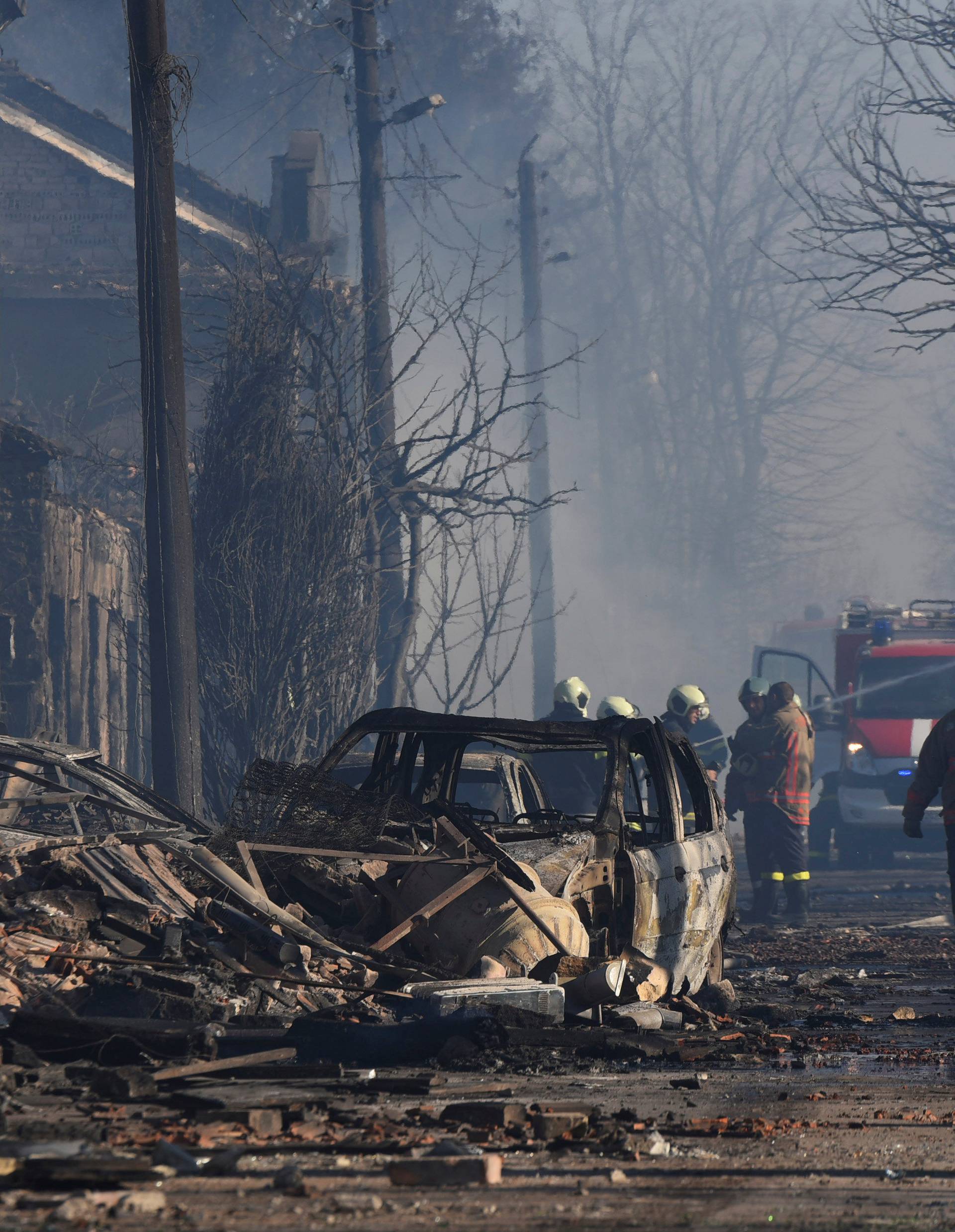 Firefighters work on the site where a cargo train derailed and exploded in the village of Hitrino