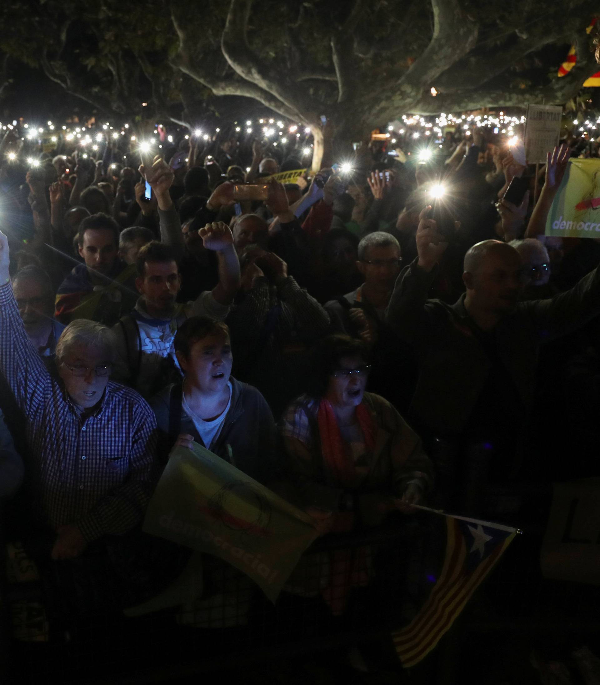 People hold their mobile phones during a gathering in support of the members of the dismissed Catalan cabinet after a Spanish judge ordered the former Catalan leaders to be remanded in cust