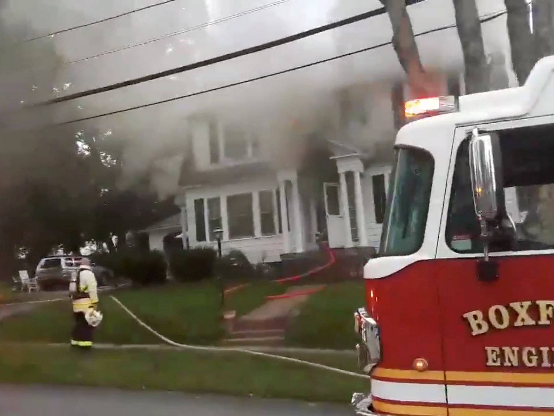 Still image from social media video footage by Boston Sparks shows firefighters working near a building emitting smoke after explosions in North Andover, Massachusetts