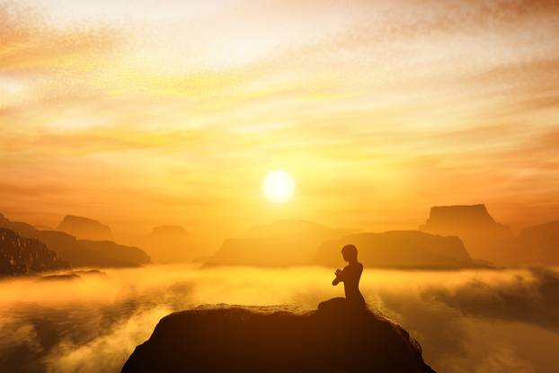 Woman meditating in sitting yoga position on the top of a mountains