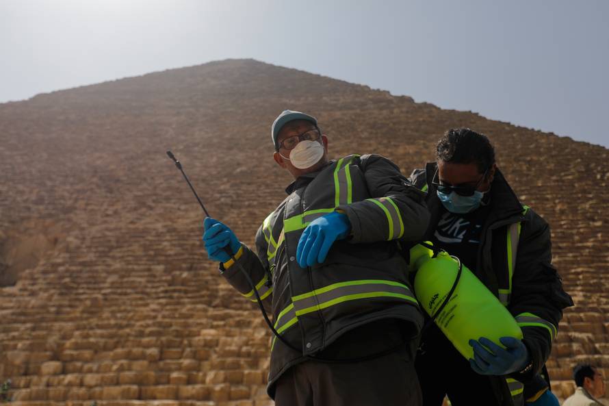 Members of the medical team prepare to spray disinfectant as a precautionary move amid concerns over the coronavirus disease (COVID-19) outbreak at the Great Pyramids, Giza, on the outskirts of Cairo