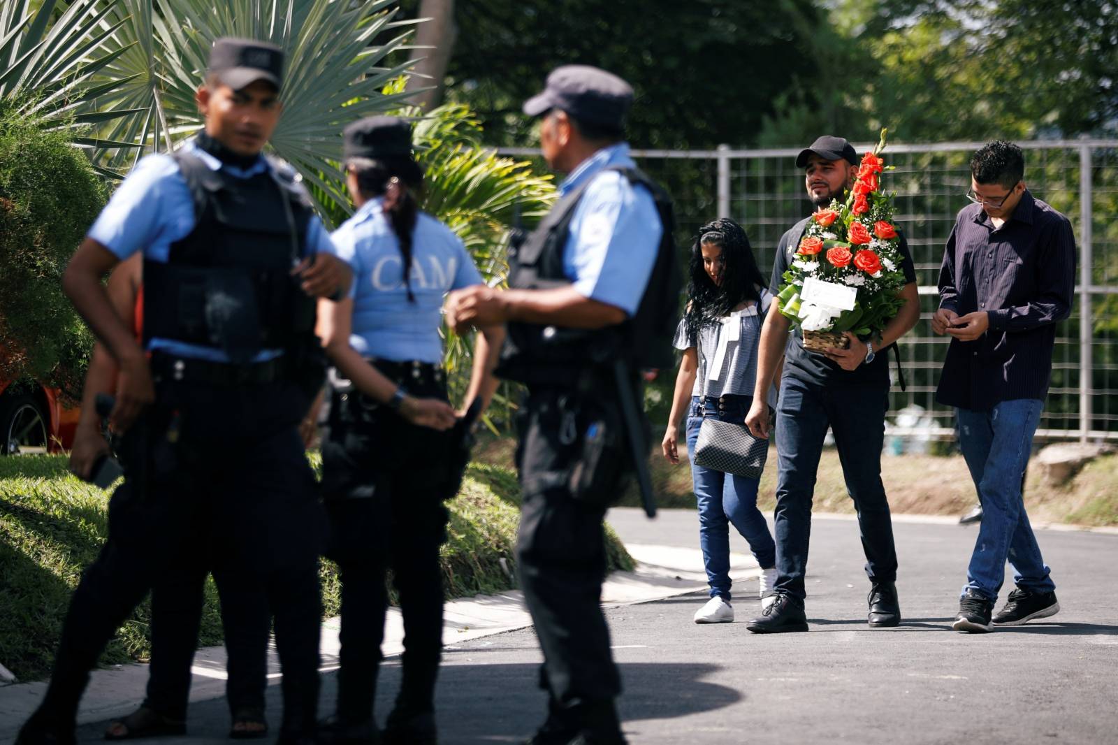 Municipal police officers secure the funeral of Oscar Alberto Martinez Ramirez and his daughter Valeria, migrants who drowned in the Rio Grande river during their journey to the U.S., at La Bermeja cemetery in San Salvador