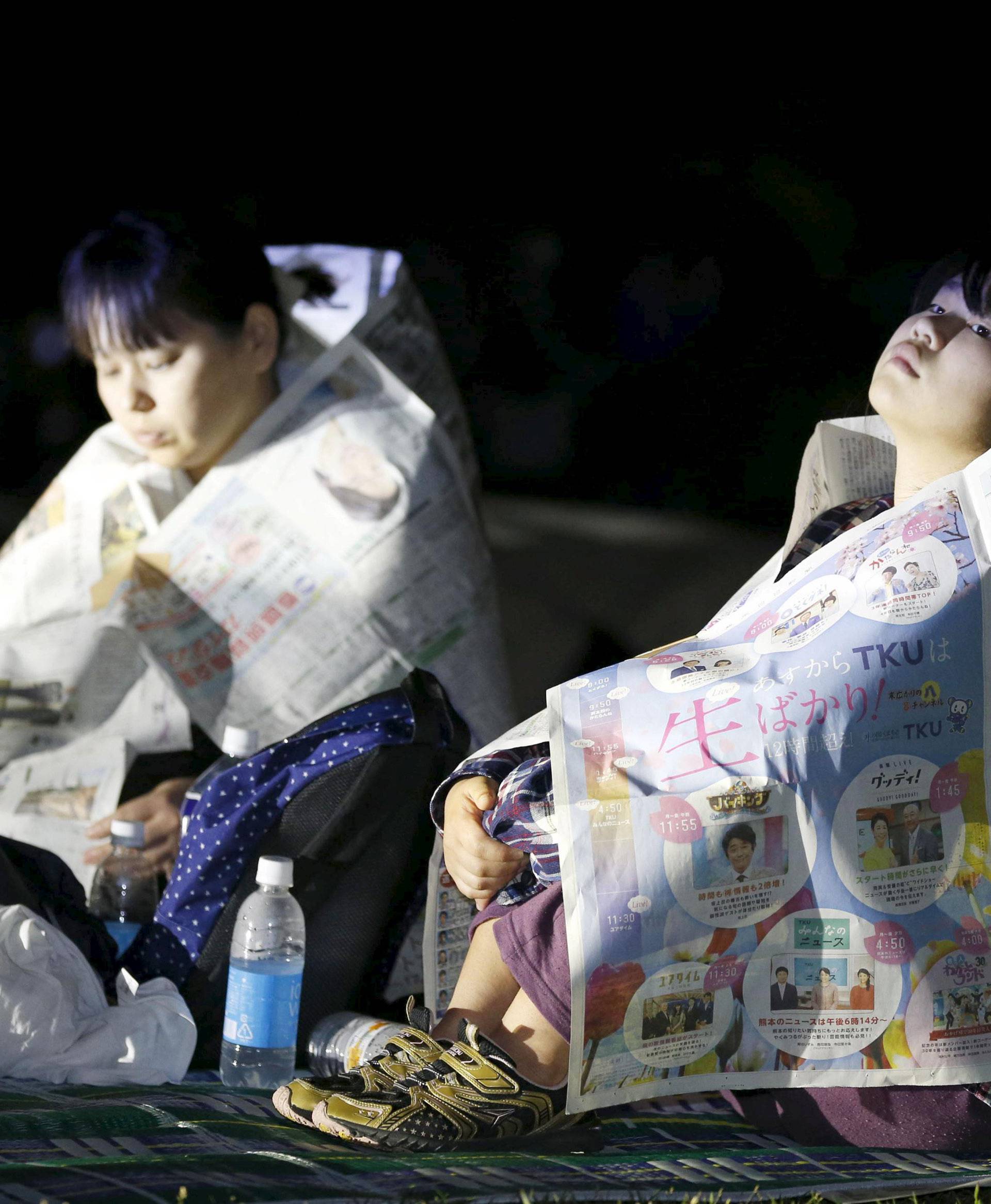 Evacuees use newspapers to warm themselves at Prefectural University of Kumamoto after an earthquake in Kumamoto, southern Japan