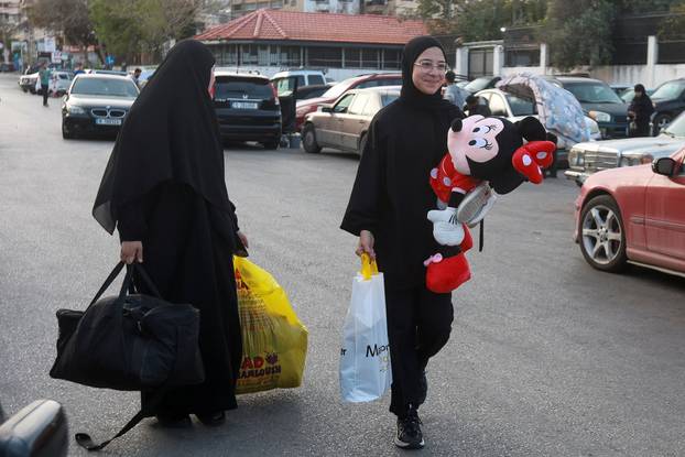 A displaced girl carrying a soft toy reacts, as people prepare to return to their homes after a 10-day ceasefire between Lebanon and Israel went into effect, in Sidon