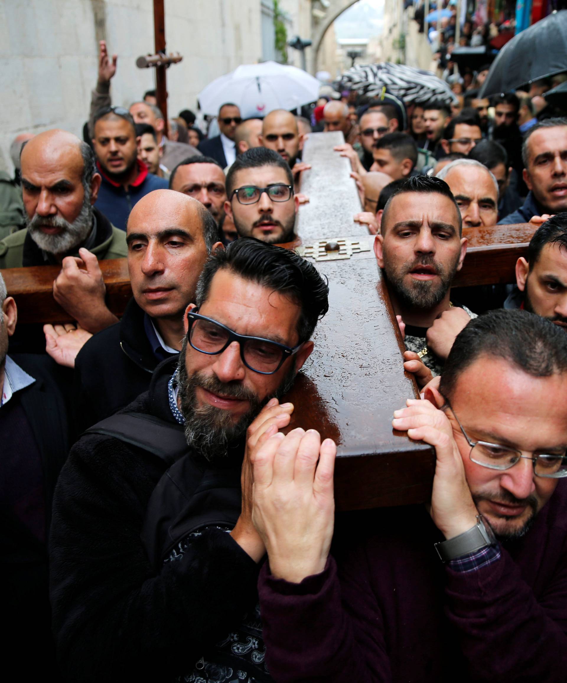 Worshippers carry a wooden cross during a Good Friday procession along the Via Dolorosa in Jerusalem's Old City