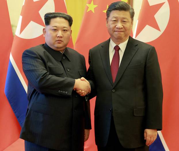 North Korean leader Kim Jong Un shakes hands with Chinese President Xi Jinping as he paid an unofficial visit to China