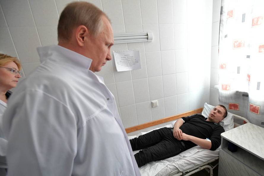 Russian President Vladimir Putin meets with victims injured during a fire in a shopping mall, at a hospital in Kemerovo