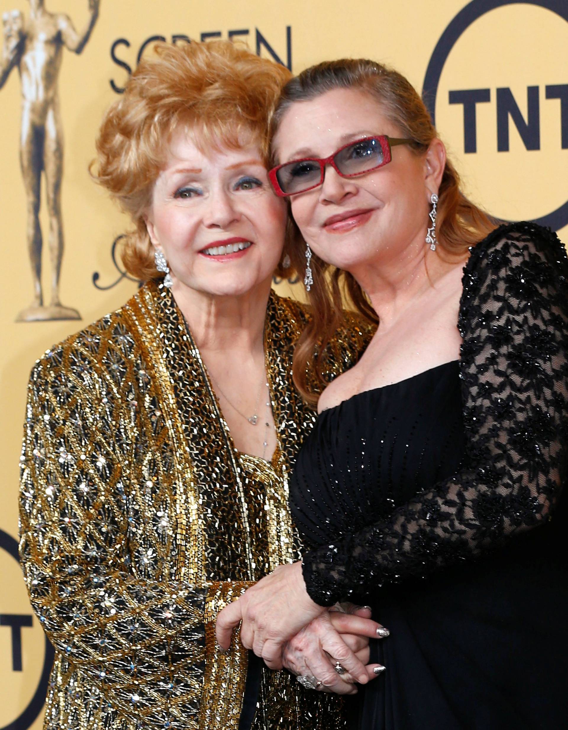FILE PHOTO: Actress Debbie Reynolds poses with her daughter actress Carrie Fisher backstage after accepting her Lifetime Achievement award at the 21st annual Screen Actors Guild Awards in Los Angeles