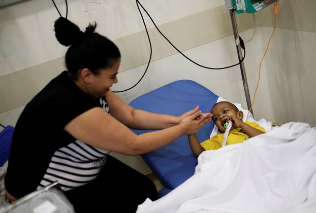Brazilian patient Lucas wears a Brazil national soccer team t-shirt next to his mother Claudia as they celebrate Neymar goal against Mexico at the Cancer Itaci Hospital in Sao Paulo