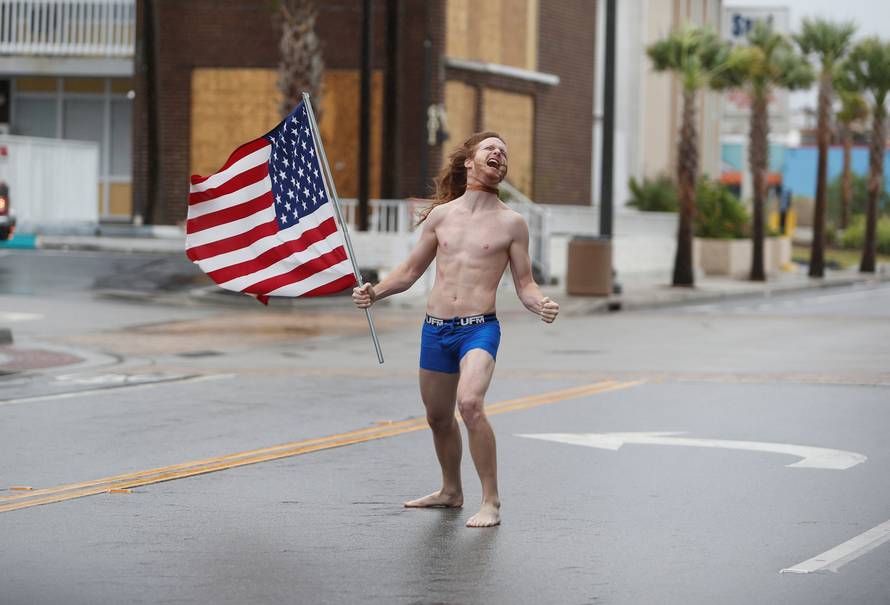 Lane Pittman of Jacksonville, Florida, stands in the wind and rain along Ocean Boulevard during Hurricane Florence in Myrtle Beach