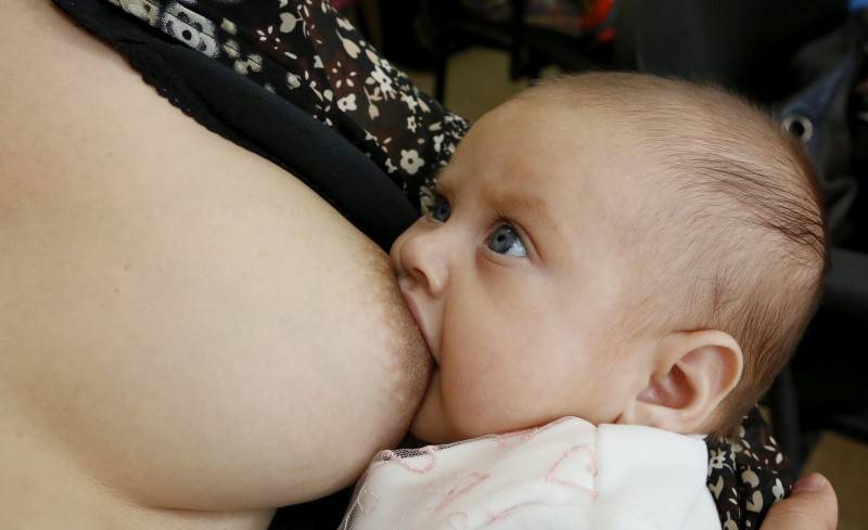 A mother breastfeeds her child together with other women during a flash mob at a children's polyclinic in the Siberian city of Krasnoyarsk, Russia